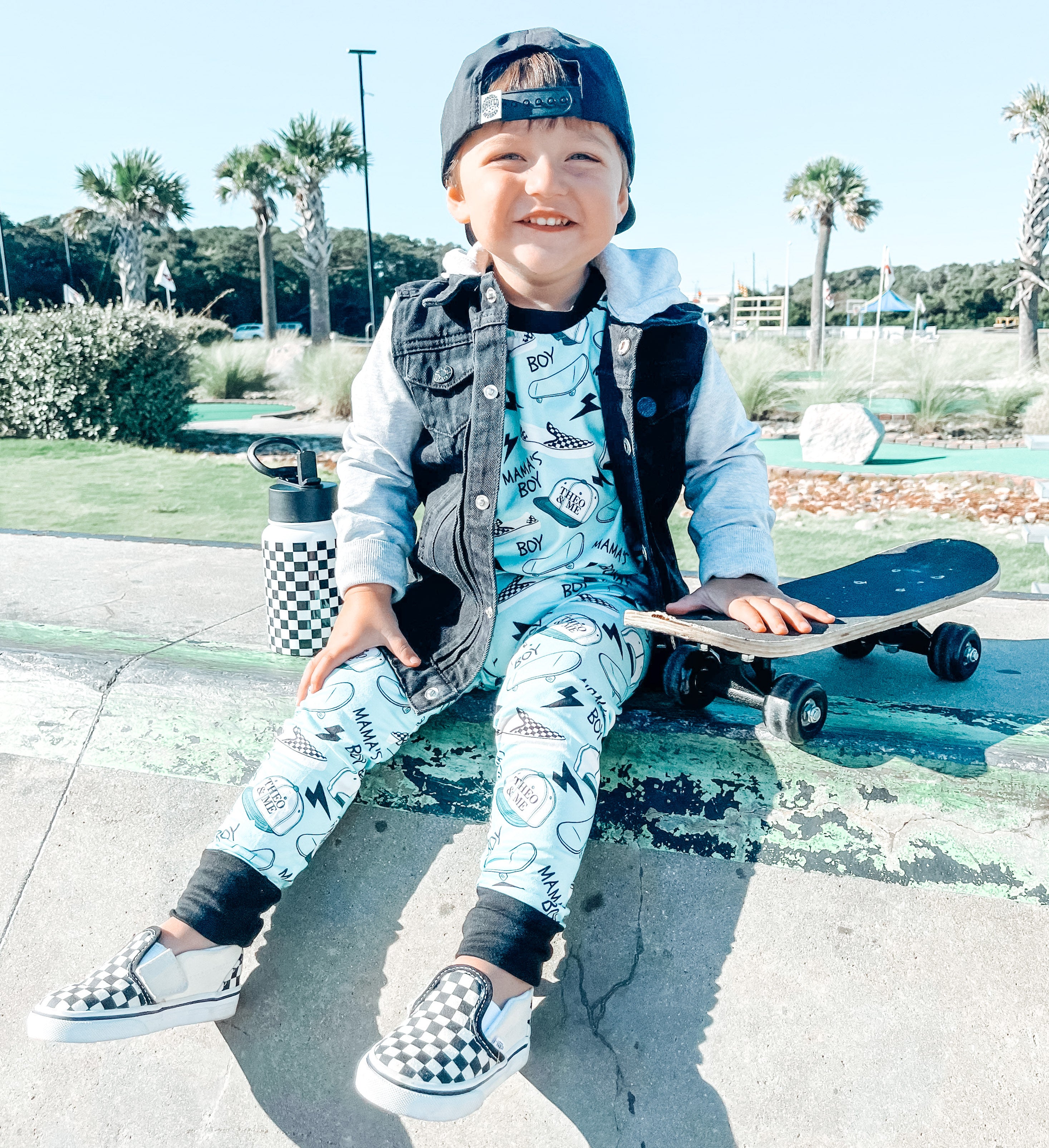 Boy wearing the Boys 2-Piece Short Sleeve Pajamas - Blue Mamas Boy Skateboards plus lightning bolts, sneakers, and theo & me hats as the pattern