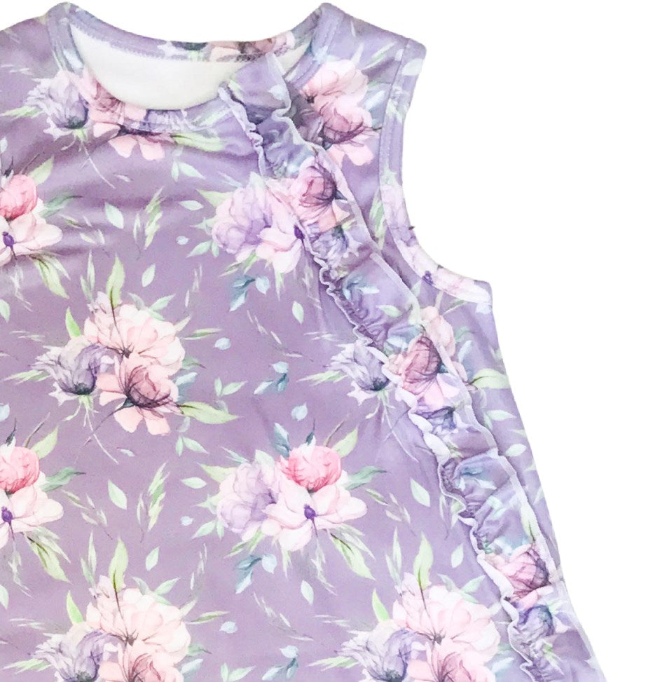 up close details on the baby sleeveless sleep bag with purple peony floral print. Shows zipper located on the right side of the photo and has ruffles. zipper will be on left side of baby when worn.