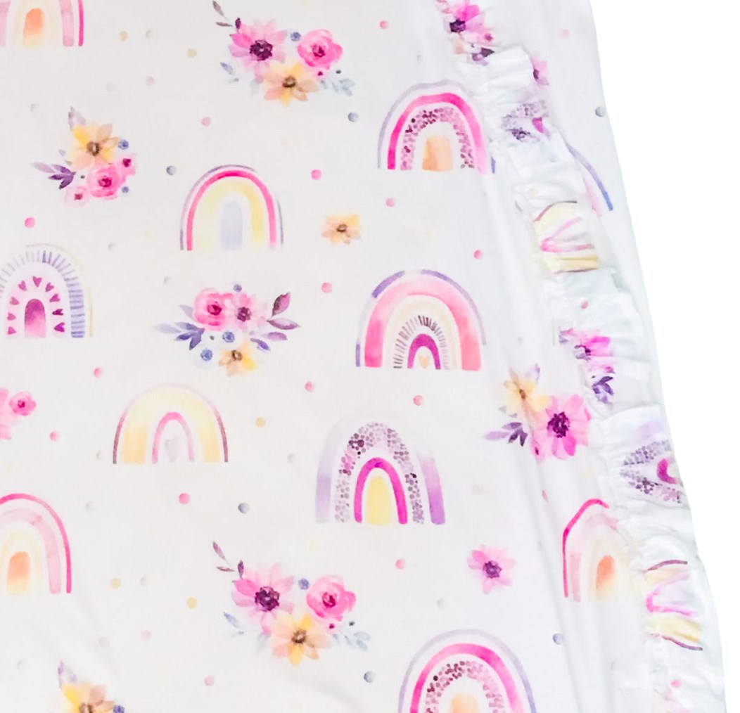 up close details on the baby sleeveless sleep bag with pink rainbows print. Shows zipper located on the right side of the photo and has ruffles. zipper will be on left side of baby when worn.
