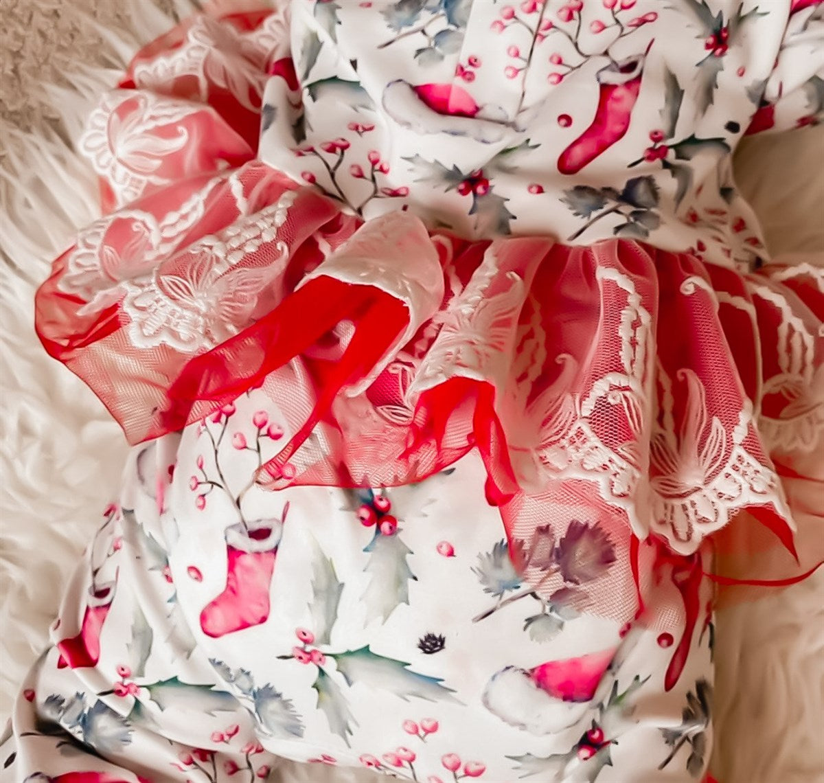 child wearing the Kryssi Kouture Sienna Holiday Infant Deluxe Tutu Jumpsuit - Red Holly Christmas Tutu. Up close of the red tutu part of the outfit.