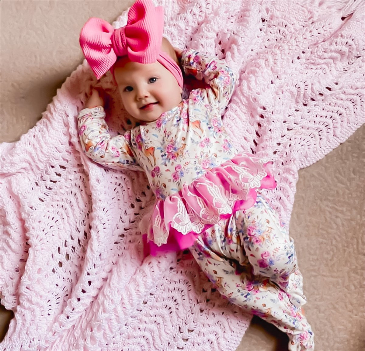 child wearing the Kryssi Kouture Sienna Holiday Infant Deluxe Tutu Jumpsuit - Deer Flora - Tutu. with a pink head bow.