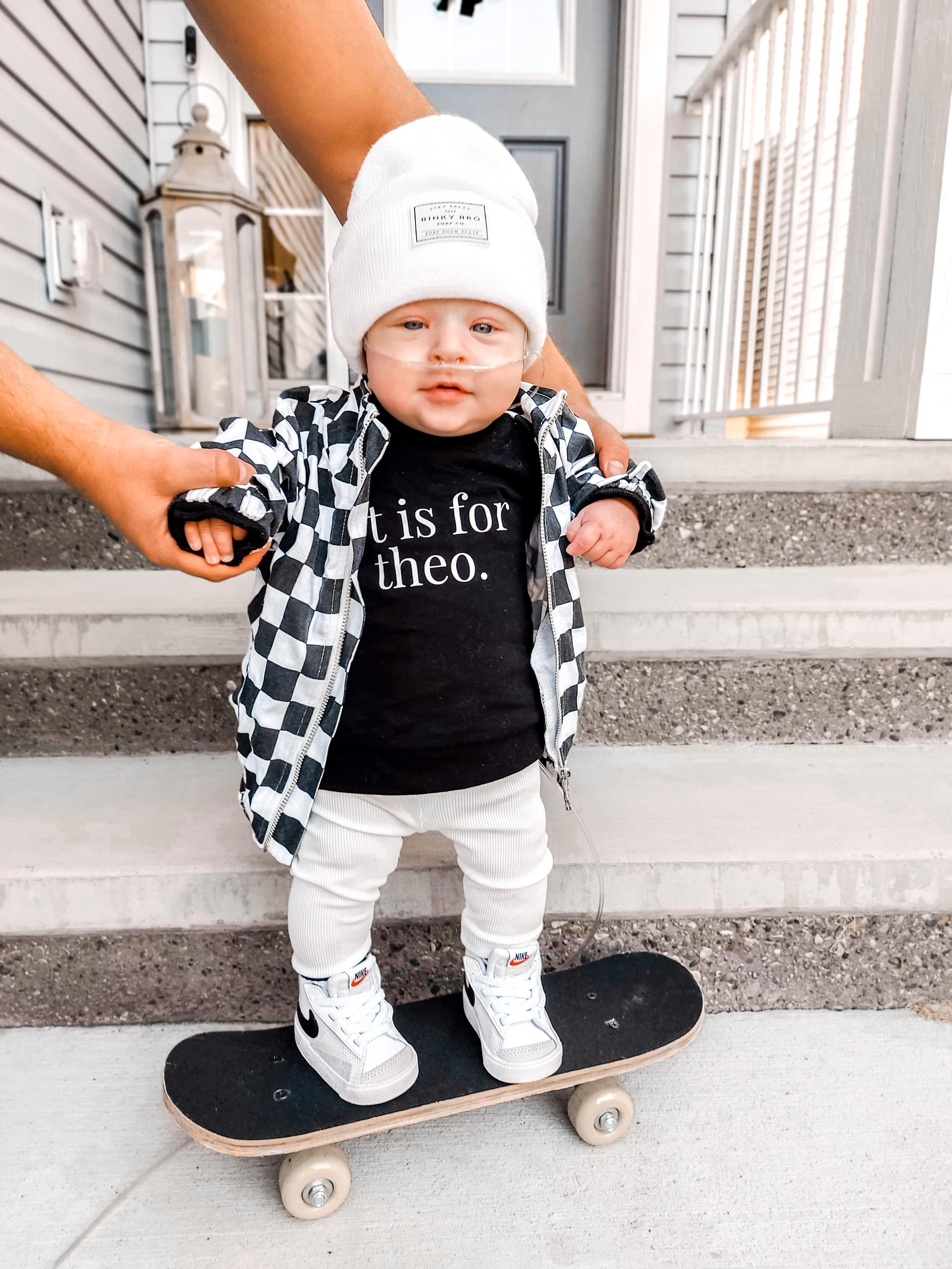 boy on a skateboard in the white and black check/block jacket