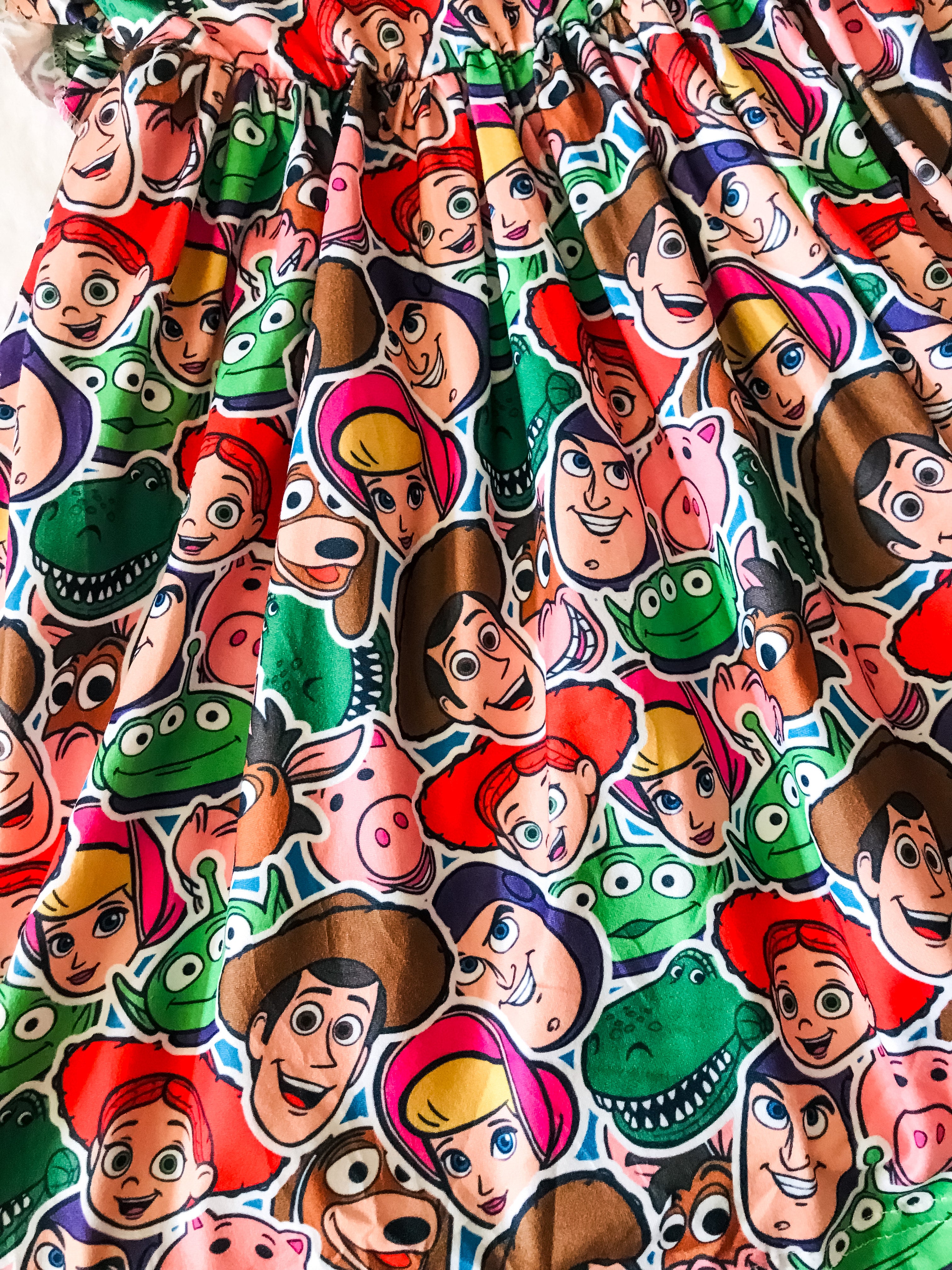 close up of Girls Fun Character Dresses - Andy's Friends Heads | Red & Green - toy story characters, bo peep, aliens, porky, dino, woody, buzz lightyear, jessie, slinky dog