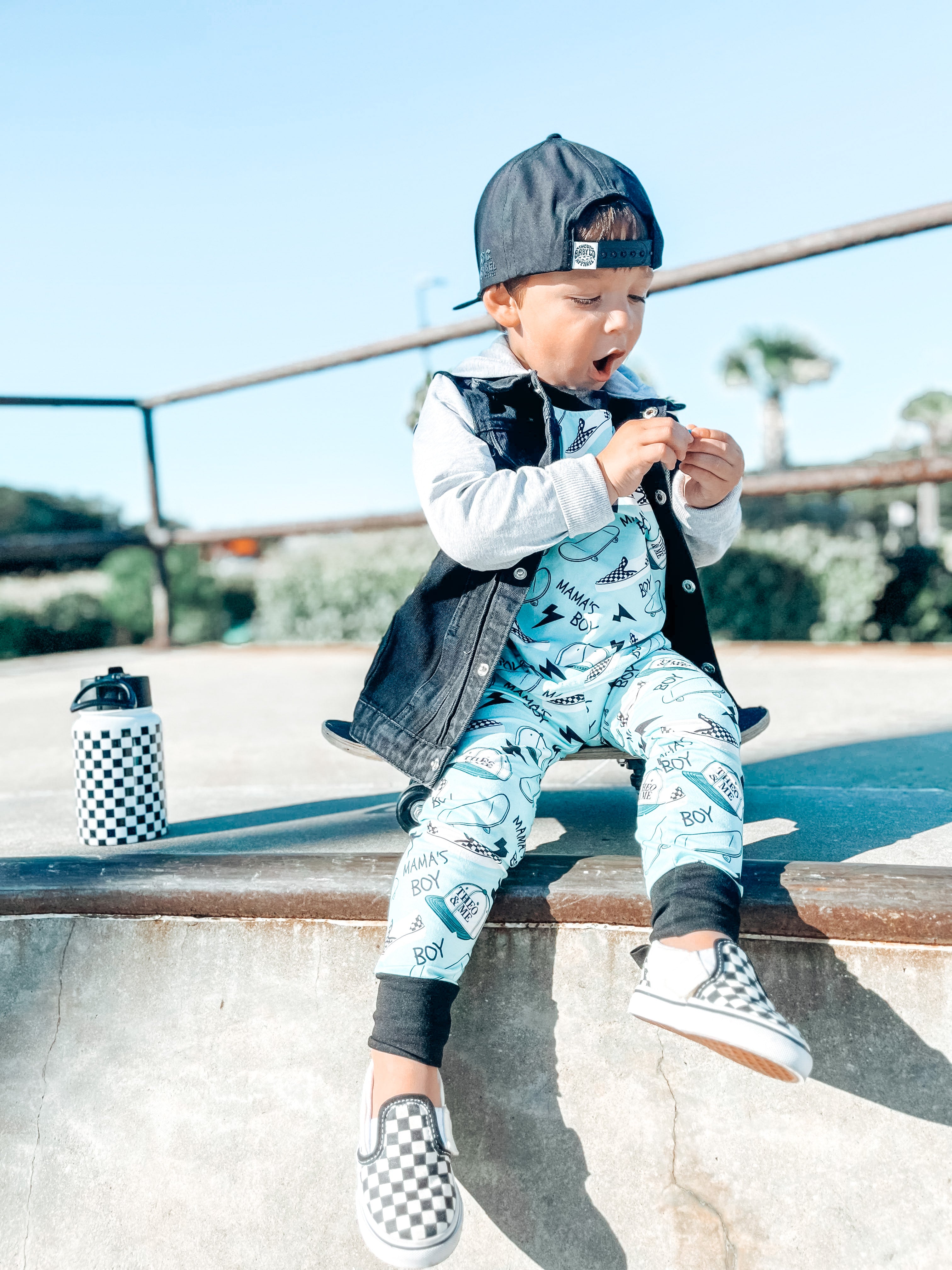 Boy wearing the Boys 2-Piece Short Sleeve Pajamas - Blue Mamas Boy Skateboards plus lightning bolts, sneakers, and theo & me hats as the pattern