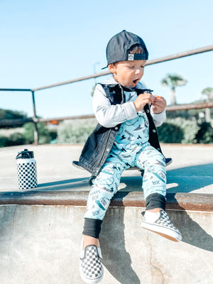 Boy wearing the Boys 2-Piece Short Sleeve Pajamas - Blue Mamas Boy Skateboards plus lightning bolts, sneakers, and theo & me hats as the pattern