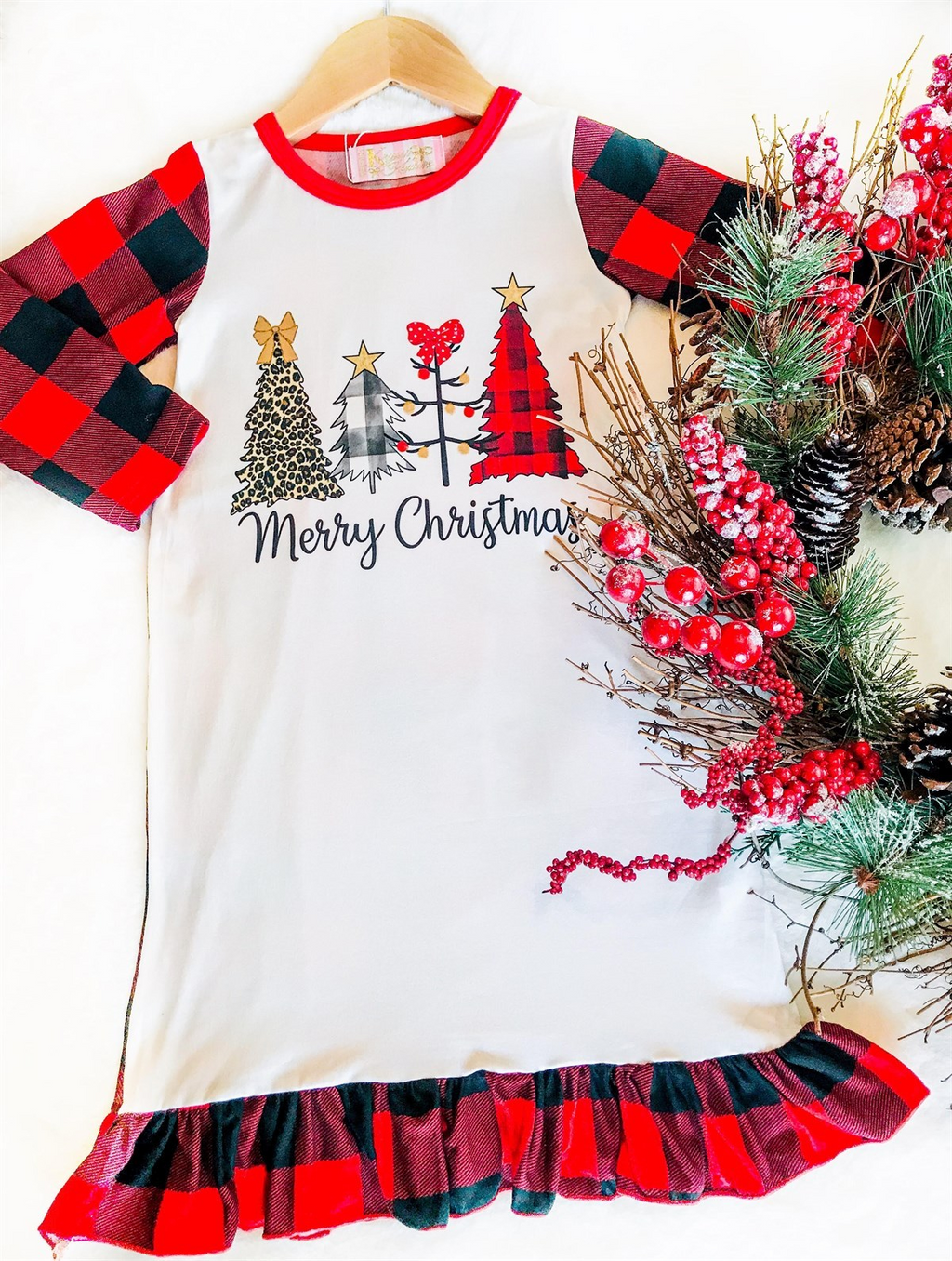Girls Christmas Night Gowns - Merry Christmas With Trees. Buffalo plaid pattern on sleeves and ruffle detailing at the bottom. 4 style christmas trees on chest including leopard, black check, stick, and buffalo plaid. Complete with Merry Christmas words on chest.