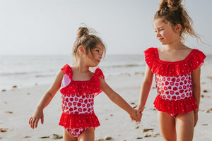 sisters wearing the Matching - Strawberry - 1 Pc Zipper Ruffle Swimsuit on the beach