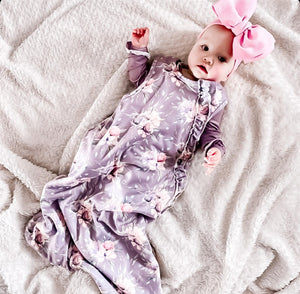 baby wearing the purple peony floral sleep bag. full length is shown to show extra room for baby growth.