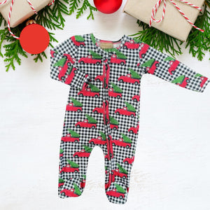 holiday zippies sleepers with black checkered pattern and red vintage trucks carrying green christmas trees