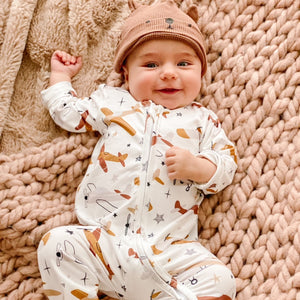 child wearing the Boys Zippies Sleepers - Airplanes with a bear beanie