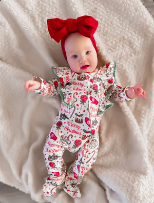 child wearing the Kryssi Kouture Sienna Holiday Infant Deluxe Tutu Jumpsuit - Red & Green Merry Christmas Pom, with a red head wrap