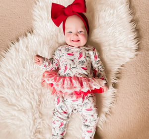 child wearing the Kryssi Kouture Sienna Holiday Infant Deluxe Tutu Jumpsuit - Red Holly Christmas Tutu. With a red head wrap.
