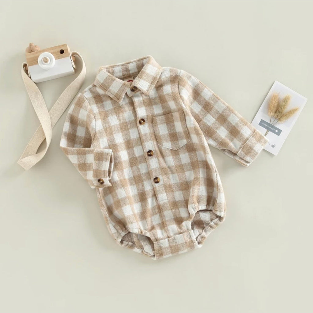brown check flannel romper with a collar, buttons down the chest, and a pocket over the heart area.