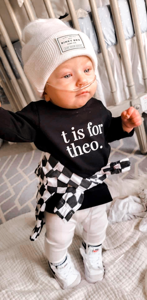child in t is for theo shirt with black and white check jacket tied at waist
