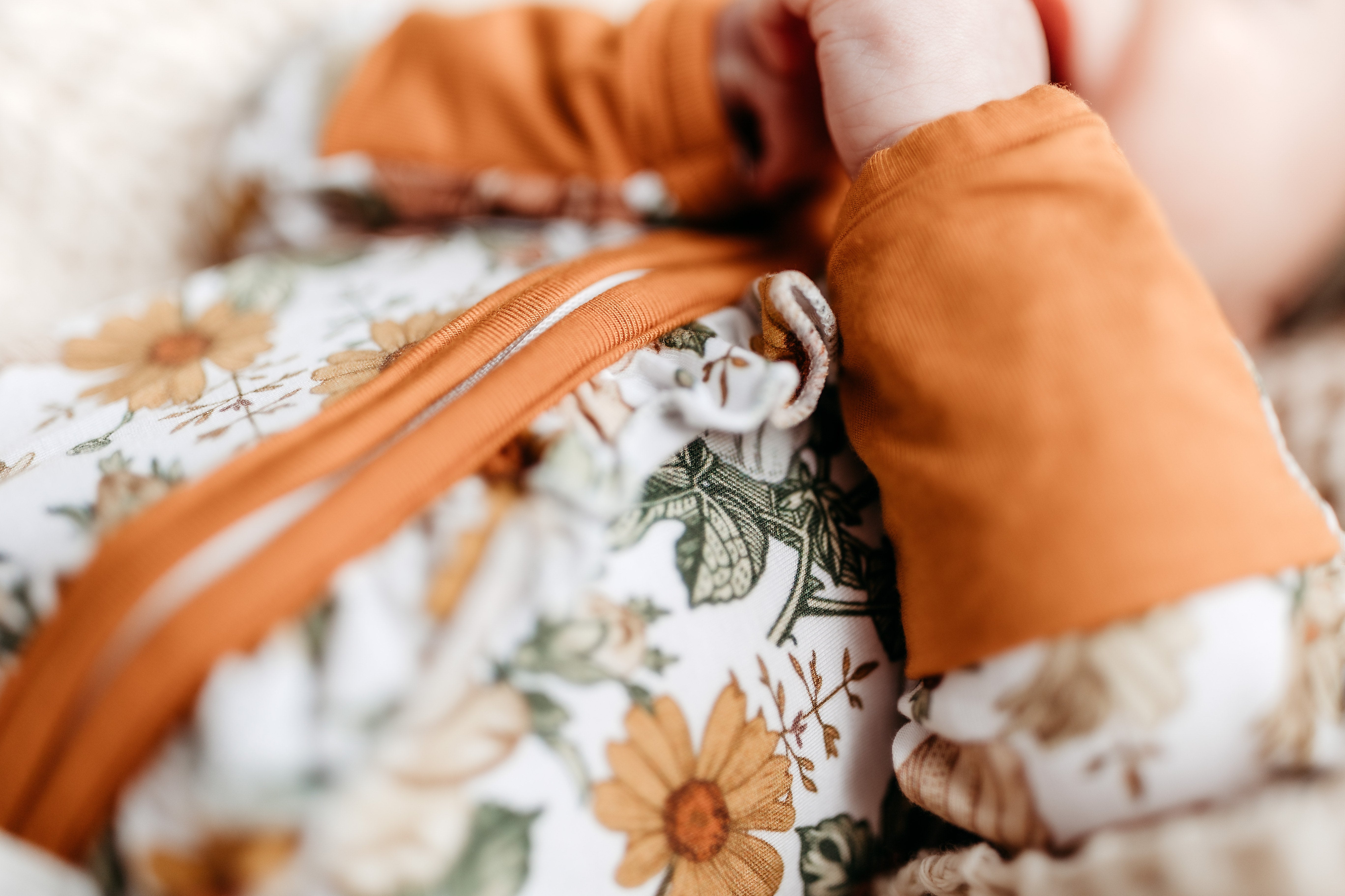 Neutral Printed Bamboo Ruffle Zippies - Floral Melody - showing hand cuffs & ruffle details along the zipper
