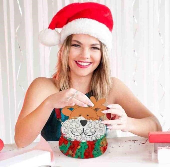 woman holding the kids reindeer pop-it purse with red strap