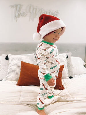 Kid wearing a 2 Pc Green Skateboard Pajama set, with a red santa hat