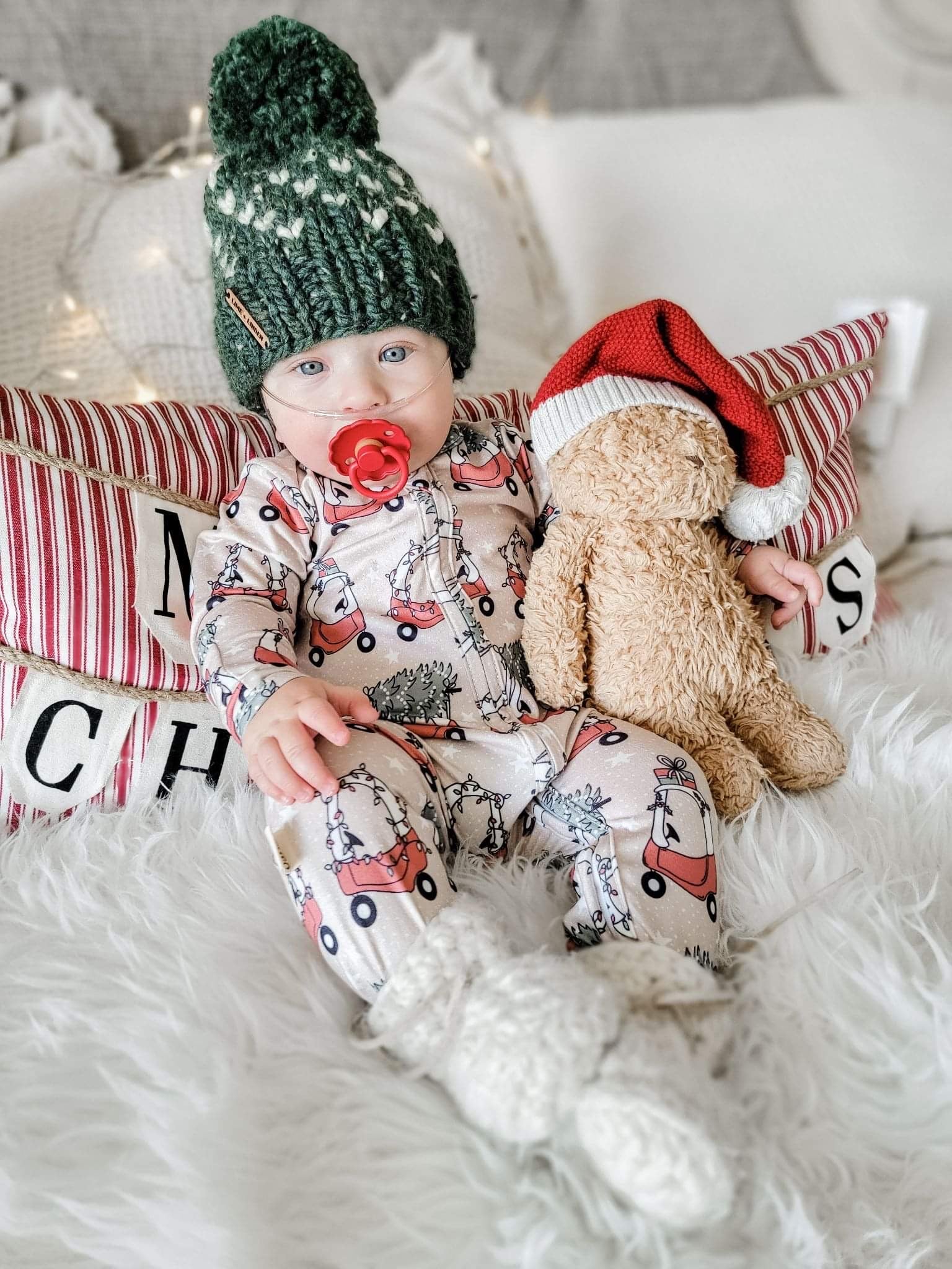 kid wearing the Holiday Baby Zippies Sleepers - Lil Tykes Car Holiday with a green knit hat & white knit socks