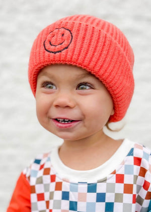 kid in hot pink happy face beanie & checkered sweatshirt
