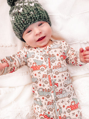 Baby wearing the Beige Vintage Trucks & Trees zippie with green pom hat